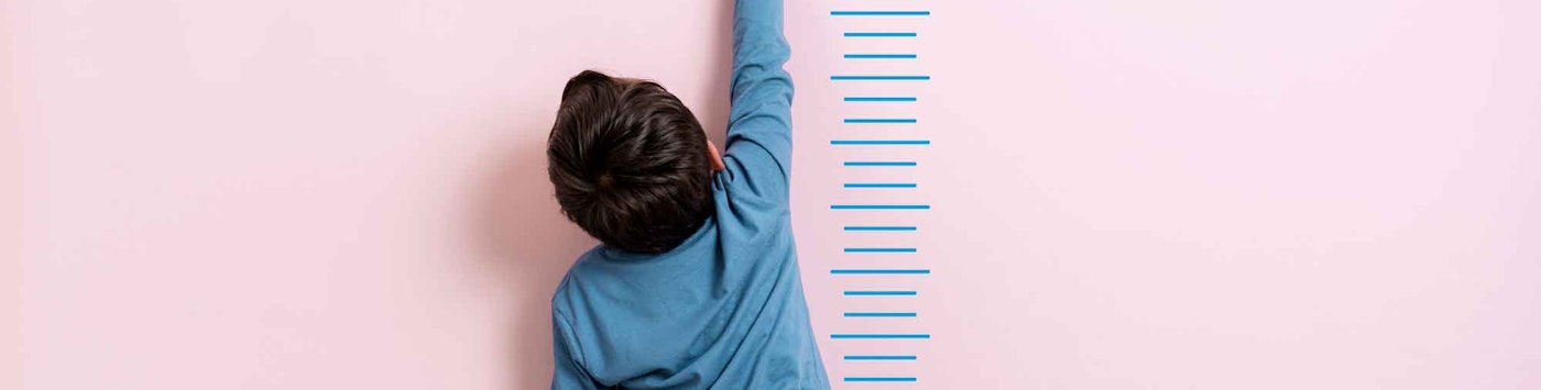 Boy reaching to target line on a height chart