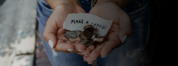 Hands holding coins and paper that says Make a Change