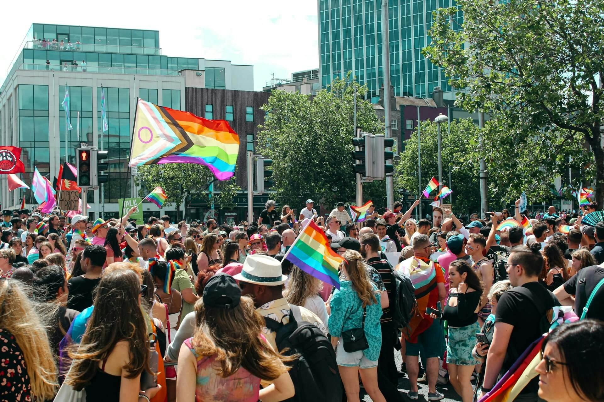 A large group of people with pride flags outside on a city street